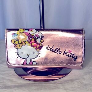 HELLO KITTY metallic pink wallet. Holds up to 16 cards. Polka dot lining inside.